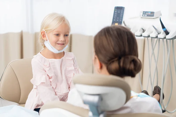 Un pediatra está sentado cerca de la chica tratando de establecer una c — Foto de Stock