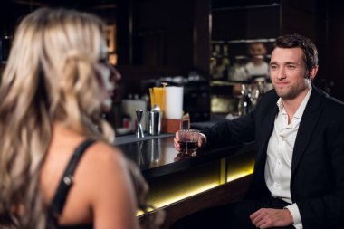 Genç ve yakışıklı bir adam barda güzel bir sarışının dikkatini çekmeye çalışıyor.