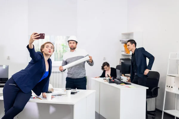 Anställda som har roligt på kontoret, poserar, gör roliga ansikten en — Stockfoto