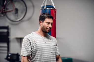 Boks koçu genç bir erkek boksör spor salonunda antrenman için hazırlanıyor..