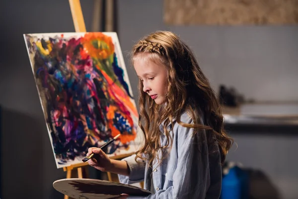 Clase de pintura abstracta. Una niña linda escribe una imagen en color en aceite o acrílico técnica. —  Fotos de Stock