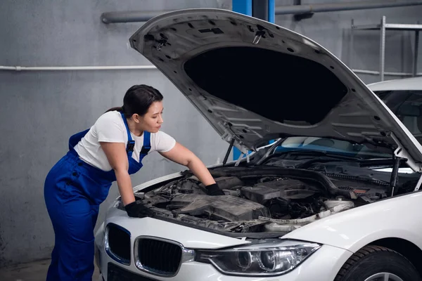 En reparatör inspekterar motorn i en bil — Stockfoto