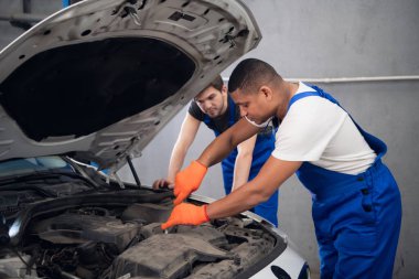 Tamirciler motor ve kaputu inceliyor.