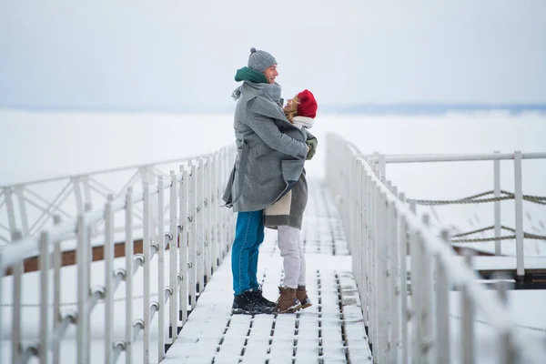 A meeting of a couple in love in winter on a pier on a frozen lake — Stock Photo, Image