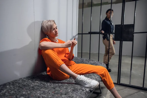 Дівчина засуджена наркоторговця в апельсиновому комбінезоні в камері на в'язниці — стокове фото