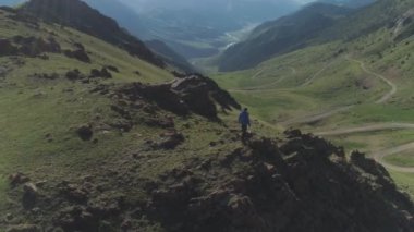 Yürüyüşçü adam dağın tepesinde duruyor.