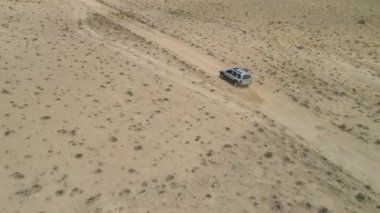 SUV arabası kumlu çöl arazisine gidiyor. 