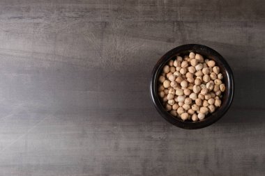 Ahşap bir tahtanın üzerinde pişmemiş nohut güveci. -