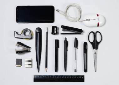 Ofis eşyaları ve iş unsurları cetvel, kalem, silgi, kalem açacağı, not defteri, mektup açacağı, ataç, makas, zımba zımbası, kanca çıkarıcı, sd hafıza kartı, yapıştırıcı bant, cep telefonu, usb kablosu, keski, yaratıcı kavram kavramı gibi bir masanın üzerinde.