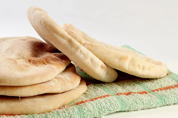 新烘焙的薄饼或阿拉伯面包 铺在乡村布和白色表面的木板上 — 图库照片