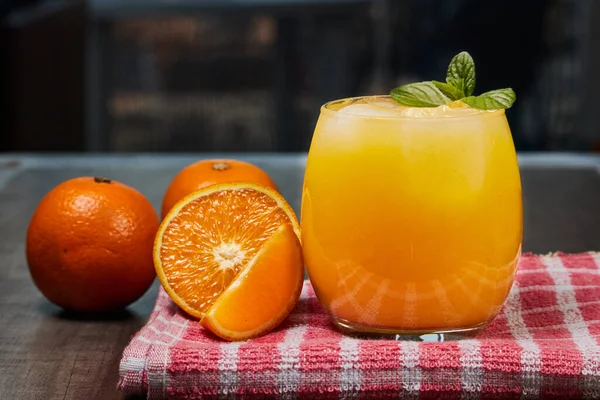 Taze portakal suyu, buz ve portakallarla dolu serinletici bardaklar.