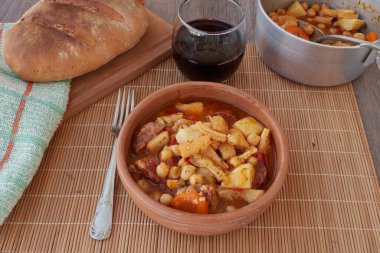 Madrid, İspanya 'nın tipik mutfağının tabağı. Mondongo a la espanola ya da cayos a la espanola. İşkembe, et, sucuk, nohut ve sebze ve domates soslu patatesten yapılmış. Ahşap bir masa ve çeşitli additi üzerinde bir toprak kabında sunuluyor.