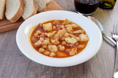 Madrid, İspanya 'nın tipik mutfağının tabağı. Mondongo a la espanola ya da cayos a la espanola. İşkembe, et, sucuk, nohut ve sebze ve domates soslu patatesten yapılmış. Tahta bir masada beyaz bir tabakta ve çeşitli ilavelerde sunuluyor.