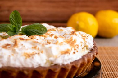 Lezzetli limonlu pasta ve nane yapraklı masa örtüsü.