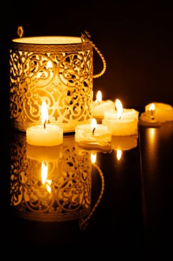 İçsel metal mum tutacağı, karanlık oturma odasındaki siyah taş masada ışık kokulu bir mum sergilenir..