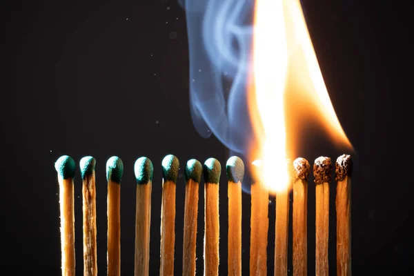 Line of matches without distance where they are lit one by one spreading the fire. The COVID-19 virus spreads the same if there is not enough distance between people