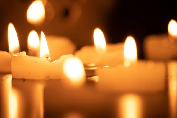 Ahşap masada yanan mumları kapatın. Arka planda bulanık Noel mumları olsun.
