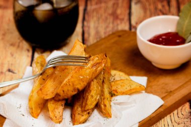 Kırsal ya da taşra usulü patates kızartması, ahşap bir tahtanın üzerinde seramik bir kasede mangal sosu ve ahşap bir masada otlu mayonez.