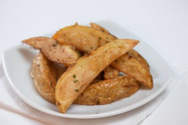Rustik ya da Country Style Herb patates kızartması küçük bir tabakta barbekü sosu ve Herb Mayonez ve beyaz bir yüzey üzerinde