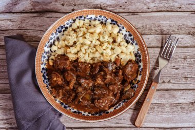 Geleneksel Macar mutfağını temsil eden spaetzle ve otlarla servis edilen sığır güveci.