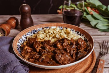 Buharda pişmiş gulaş, spaetzle mantı ile servis edilir, lezzetli ve lezzetli bir Macar yemeği yaratır.