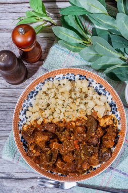 Macar sığır eti güveci spaetzle köfteleriyle servis edilir ve bu da sağlıklı ve geleneksel bir yemek oluşturur.