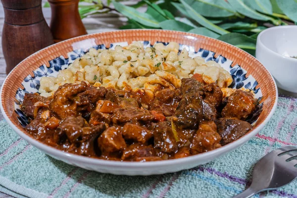 Macar tas kebabı spaetzle ile servis edilir, lezzetli ve lezzetli bir yemek oluşturur.