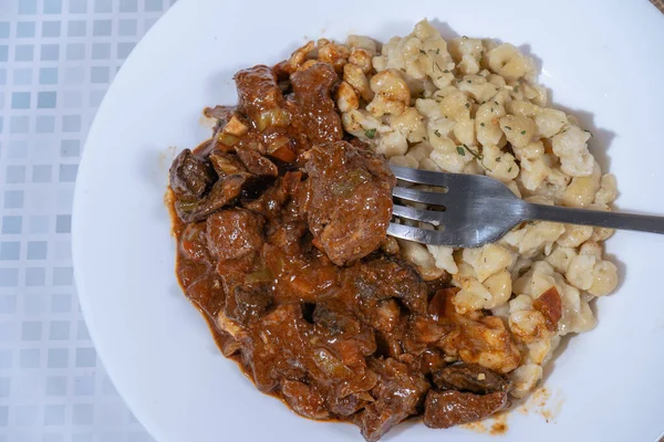 Spaetzle ve mantarlı leziz sığır kebabı, doyurucu ve lezzetli geleneksel bir yemek.