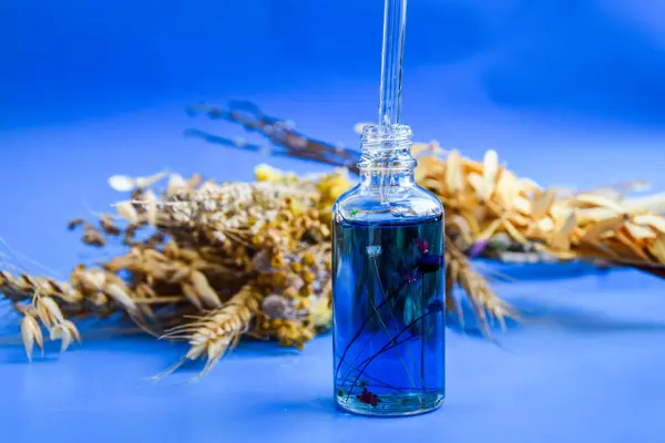 Contagocce Vetro Con Una Goccia Olio Cosmetico Fiori Secchi Sfondo — Foto Stock