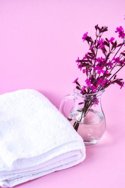 Temiz ve taze pamuk havlular, pembe arka planda çiçek açan dallı spa tedavisi, fotokopi alanı, spa dekorasyonu.