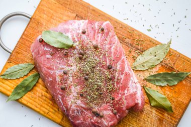 Tahta kesme tahtasının üzerinde defne yaprağı olan taze et manzarası, çiğ et. Taze sığır eti, fotokopi alanı, biftek.