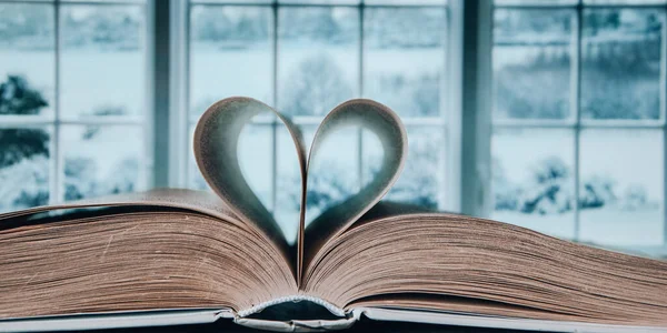 ウィンドウの背景に隔離された愛のシンボルを持つ本 愛の本 愛の物語 紙の本から心の形 本とロマンチックな背景 — ストック写真