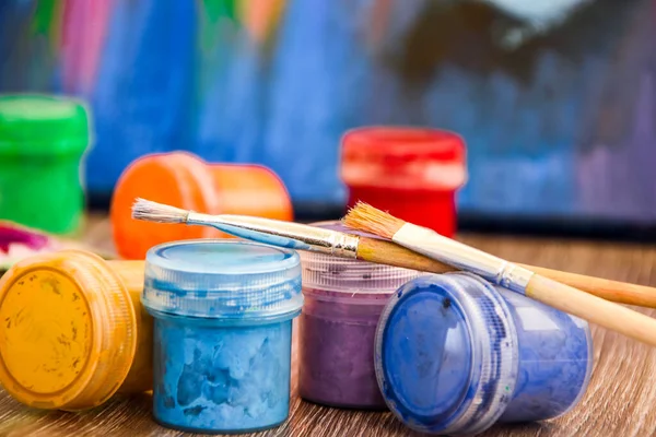 A set of paints for body painting. workplace, Paints, brushes and palette on the colorful background. The workplace of the artist. Banner for school