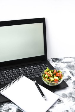Ofiste sağlıklı iş yemeği, sebze salatası, kalemli boş defter, fotokopi alanı, düşük kalori diyeti.
