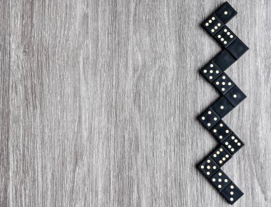 Açık tahta masadaki siyah Domino zarlarının üst görünümü, domino oynama süreci, kopyalama alanı, masa oyunu