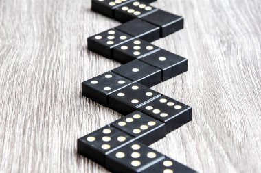Siyah Domino zarları açık tahta bir masada, domino oynama süreci, seçici odaklanma, yakın plan, masa oyunu