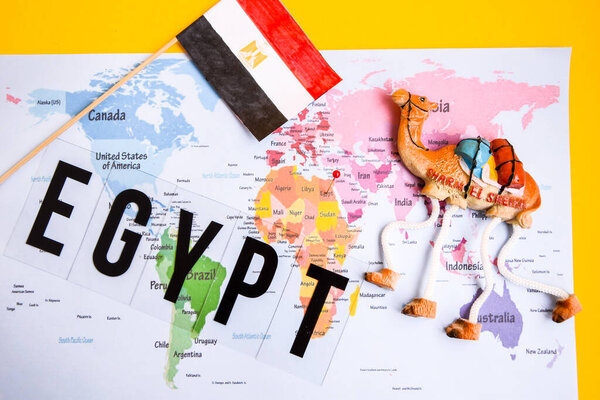 Egypt travel concept, camel magnet, egypt flag over world map, boarding pass with passport