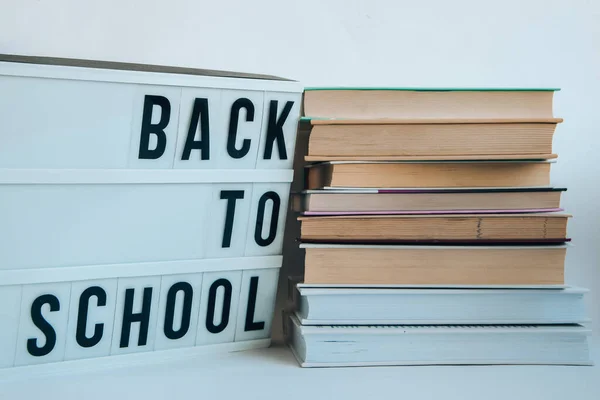 バックとライトボックスに学校のテキストと白い背景の本 古い本の教育の概念の背景のスタック テキストのためのコピースペースを持つ多くの本の山 — ストック写真