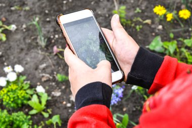 Akıllı telefonu olan küçük bir çocuk yeni teknolojilerde ustalaşıyor, fotoğraf çekiyor, küçük fotoğrafçı, seçici odaklı.