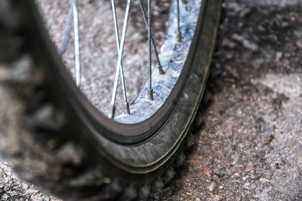 close-up bicycle wheel on road, selective focus, Bicycle wheel close up against the background of a dirt road. Bicycle parts