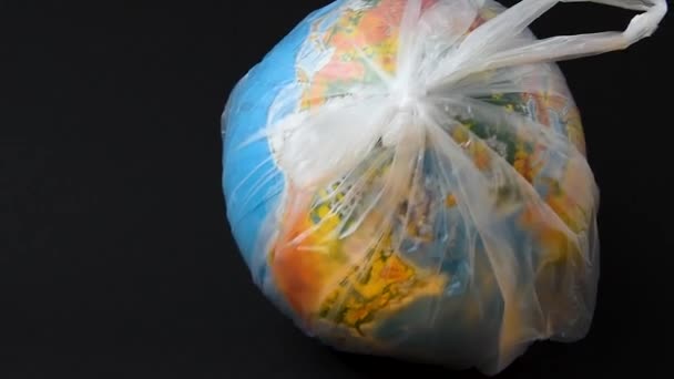 Journée mondiale de l'environnement. La terre dans un sac en plastique. Emballage jetable en polyéthylène. Réchauffement climatique dû à la pollution par les débris plastiques. — Video