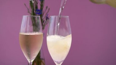 - Şampanya. İki Flüt ve Köpüklü Şarap Mor Arkaplan. Şampanya dolduruyorum..
