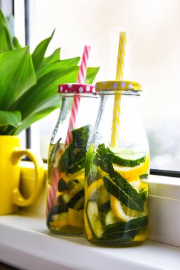 Limonata, limon ve salatalık, pencere kenarındaki nane yaprakları, yaz ferahlatıcı detoks içecekleri, seçici odak, vadideki zambak çiçeği.