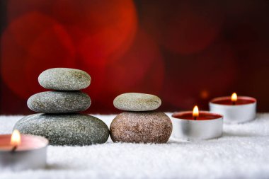 Zen konsepti, spa çakıl taşları ve bulanık arka planda yanan aroma mumları, aromaterapi ve masaj, metin için kopyalama alanı