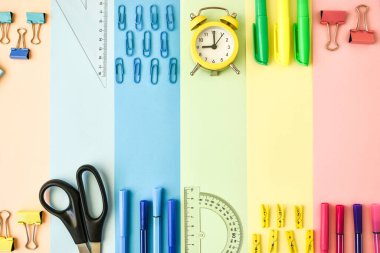 Renkli kağıt arkaplan çerçevesinde okul malzemeleri. Renkli bir geçmişi olan okul ya da ofis kırtasiyesi. Okula geri dön. Çerçeve, kopyalama alanı. Üst görünüm
