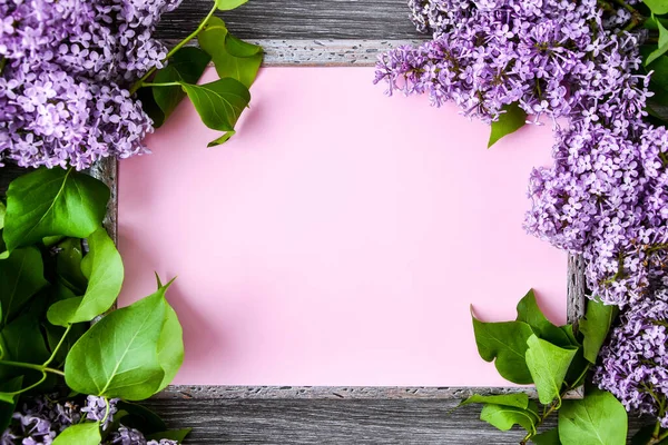 Spring flowers. Lilac flowers on wooden background. Top view, flat lay, copy space for text, Lilac blossom branches frame