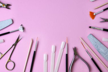Pembe arka planda manikür ve pedikür aletleri, yukarıdan görüş. Manikür salonu afiş tasarım şablonu. Güzellik tedavisi konsepti. Metin için alanı kopyala