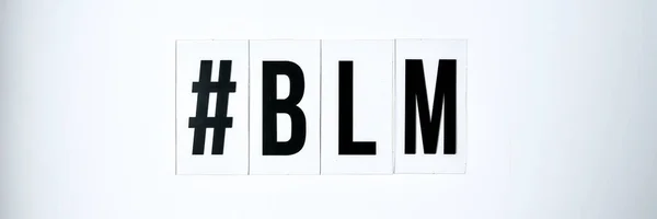 hashtag BLM BLACK LIVES MATTER text on a white background. Protest against the end of racism, anti-racism, equality. Poster on violation of human rights