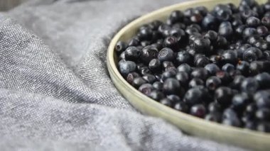 Ağır çekimde dönen yaban mersinlerini kaseye koy. Seçici odaklanma. Yabanmersini dönüşümlü arka plan. Taze ve olgun organik yabanmersini rotası. Diyet, diyet, sağlıklı vejetaryen yemekleri. Organik