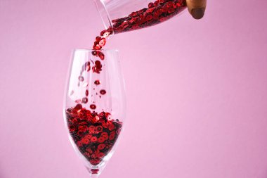 Kırmızı konfeti pembe arka planda şampanya bardağına düşer, metin için kopyalama alanı, yaratıcı bayram bayramı kartı, sevgililer günü kartı